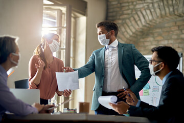 Business coworkers wearing protective face masks while having a meeting during COVID-19 epidemic.