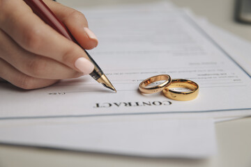 Woman signing marriage contract, closeup.