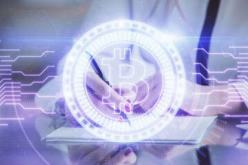 Cryptocurrency hologram over woman's hands writing background. Concept of blockchain. Double exposure