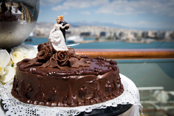 wedding chocolate cake on a plate with a wedding couple on top
