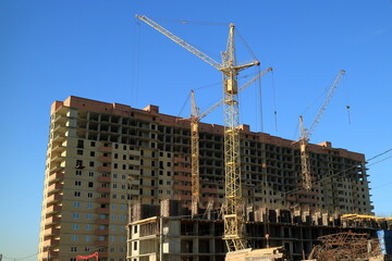 Tower cranes are working on the construction of a new house. Lifting crane.
