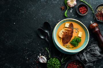 Healthy food. Pea cream soup with toast in a plate on a black stone background. Top view. Rustic style.