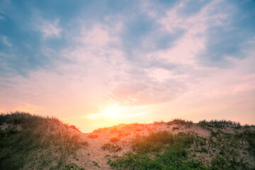 Sandy dune against evening sky. Nature landscape. Sandy hills on the beach