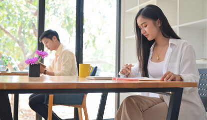 Women and men work in the Cafe.They sit in social distancing.