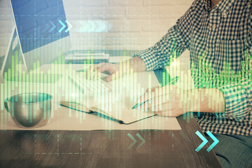 Double exposure of stock market chart with man working on computer on background. Concept of financial analysis.