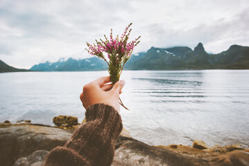 Hand holding flowers bouquet foggy mountains landscape Travel lifestyle vacations outdoor woman...