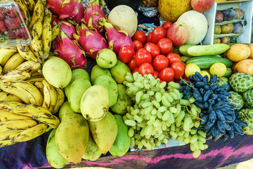 A lot different fresh tropical fruits on the counter. Fruit market