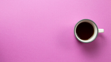 Obraz na płótnie Canvas A cup of americano coffee on pink background. top view, copy space