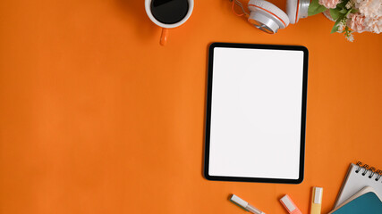 A colorful workspace is surrounding by white blank screen computer tablet and equipment.