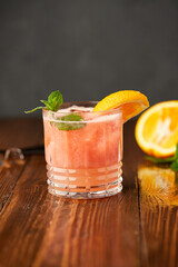 Grapefruit and orange smoothie coctail on grey wooden background. Refreshing drinks