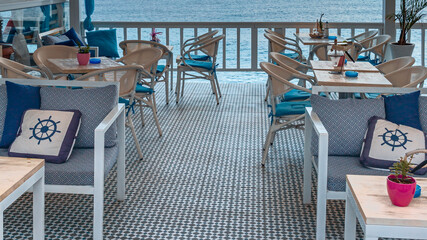 chairs and a table a coastal cafe on the Mediterranean coast in the recreation area of ​​the Greek city of Hersonissos during quarantine COVID-19