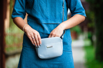 Woman's hand keeping her smartphone in her handbag while. Selective focus. Handbag. Bag in women's hands.