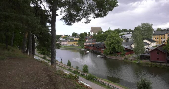 4K video of Porvoo vintage red wooden buildings, Porvoo Cathedral, yachts and boats in Porvoonjoki River near town center on sunny summer day in Finland, northern Europe