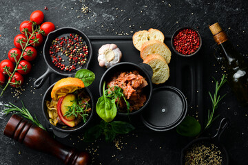 Stewed cabbage and goose liver with bacon in a metal jug. Top view. Rustic style.