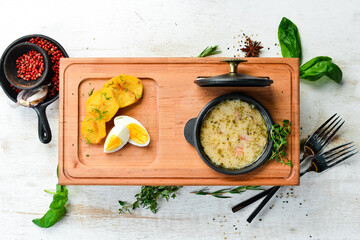 Soup with bacon, vegetables and egg. Top view. Rustic style.