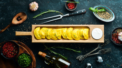 Ukrainian traditional food. Yellow potato dumplings with sour cream. Top view. Rustic style.