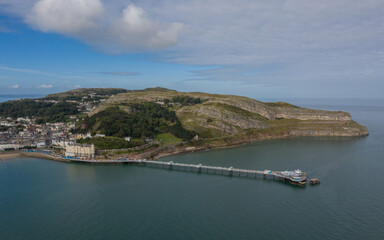Fototapeta premium Llandudno Town and Pier North wales showing Great Orme, the beach and sea. Aerial photograph