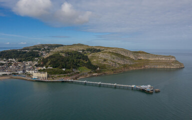 Fototapeta na wymiar Llandudno Town and Pier North wales showing Great Orme, the beach and sea. Aerial photograph