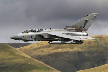 RAF (Royal Air Force) Panavia Tornado GR4 Fighter Bomber and reconnaissance jet flying low level in the UK, Cumbria, Wales and Scotland.   - obrazy, fototapety, plakaty