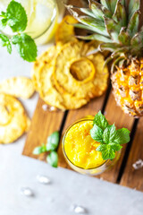 Homemade pineapple sorbet ice cream in a glass on a wooden background.
