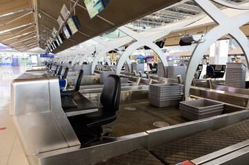 Row of empty check-in desks with luggage boxes at the airport