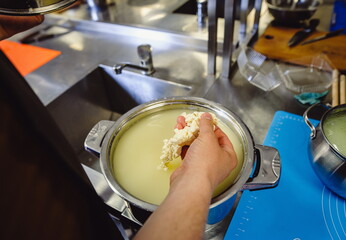 The home-made cheese maker produces handmade mozzarella with fresh quality milk. Concept: tradition, italy, mozzarella.The process of making mozzarella. Film noise
