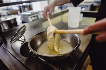The home-made cheese maker produces handmade mozzarella with fresh quality milk. Concept: tradition, italy, mozzarella.The process of making mozzarella. Film noise