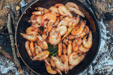 Langoustine shrimps in a pan in oil and spices are fried after cooking - a snack for beer