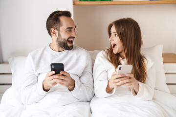 Lovely young happy couple laying in bed