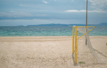 Empty beach with football goal on a sunny day on the sea and blue sky background. Preparing the beach for the game. Roses, Catalunya, Spain.