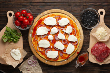 Process of making homemade pizza with mozzarella olives and salami, top view