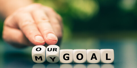Hand turns dice and changes the expression "my goal" to "our goal".