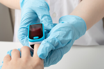 Doctor in clinic measures patient blood saturation
