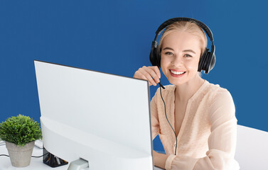 Smiling service desk consultant with headset talking to customer at call centre, empty space