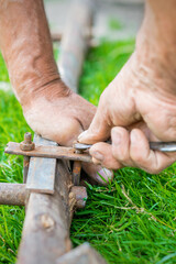 hand of an elderly man twisting the nut with a wrench outdoors. Repair by wrench.