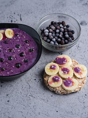 healthy delicious Breakfast blueberry smoothie cocktail of frozen berries in a bowl with a banana