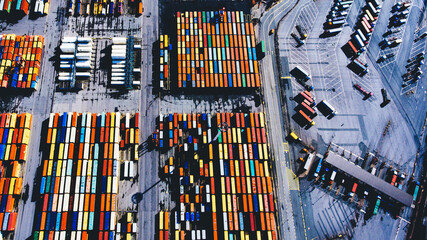 Top view aerial photo of stack of freight containers in rows at the shipyard. Big harbor with anchored track vehicles. Global Logistics Shipping industry. Export and Import transportation services