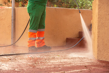 Person cleaning streets with a pressure gun