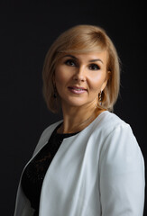 Closeup portrait of a business woman looking away. Middle aged lady isolated on black background.