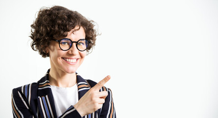 Portrait of funny business woman with glasses pointing at white background