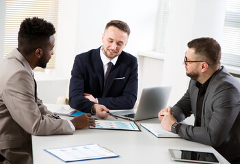 Business people are sitting around the table at a meeting in the office
