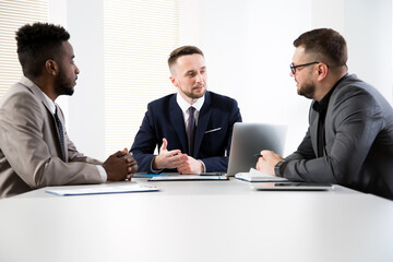 Business people are sitting around the table at a meeting in the office