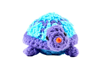 Knitted isolated baby turtle toy on a white background. Cute handmade plush toy for children.