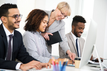 Mature businesswoman explains to young colleagues a new project