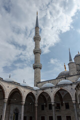 Fototapeta na wymiar View of the domed arches and minaret from the yard of the Blue Mosque. The minaret, aimed at the blue sky...
