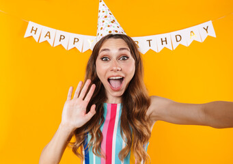 Image of joyful cute woman taking selfie photo and waving hand