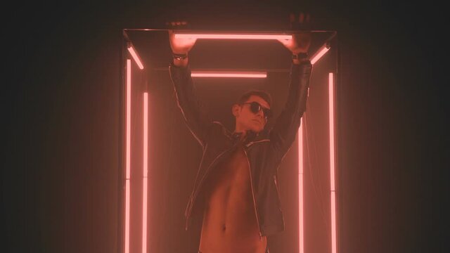 Sexy man dancing in light cube