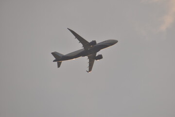 an air plain taking off in the clouds during sunset in india.