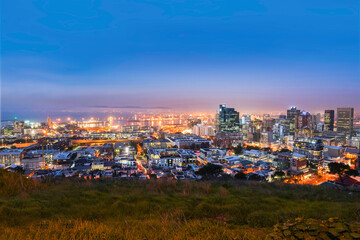 Fototapeta premium Cape Town city CBD skyline illuminated at night with blue sky