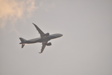 an air plain taking off in the clouds during sunset in india.